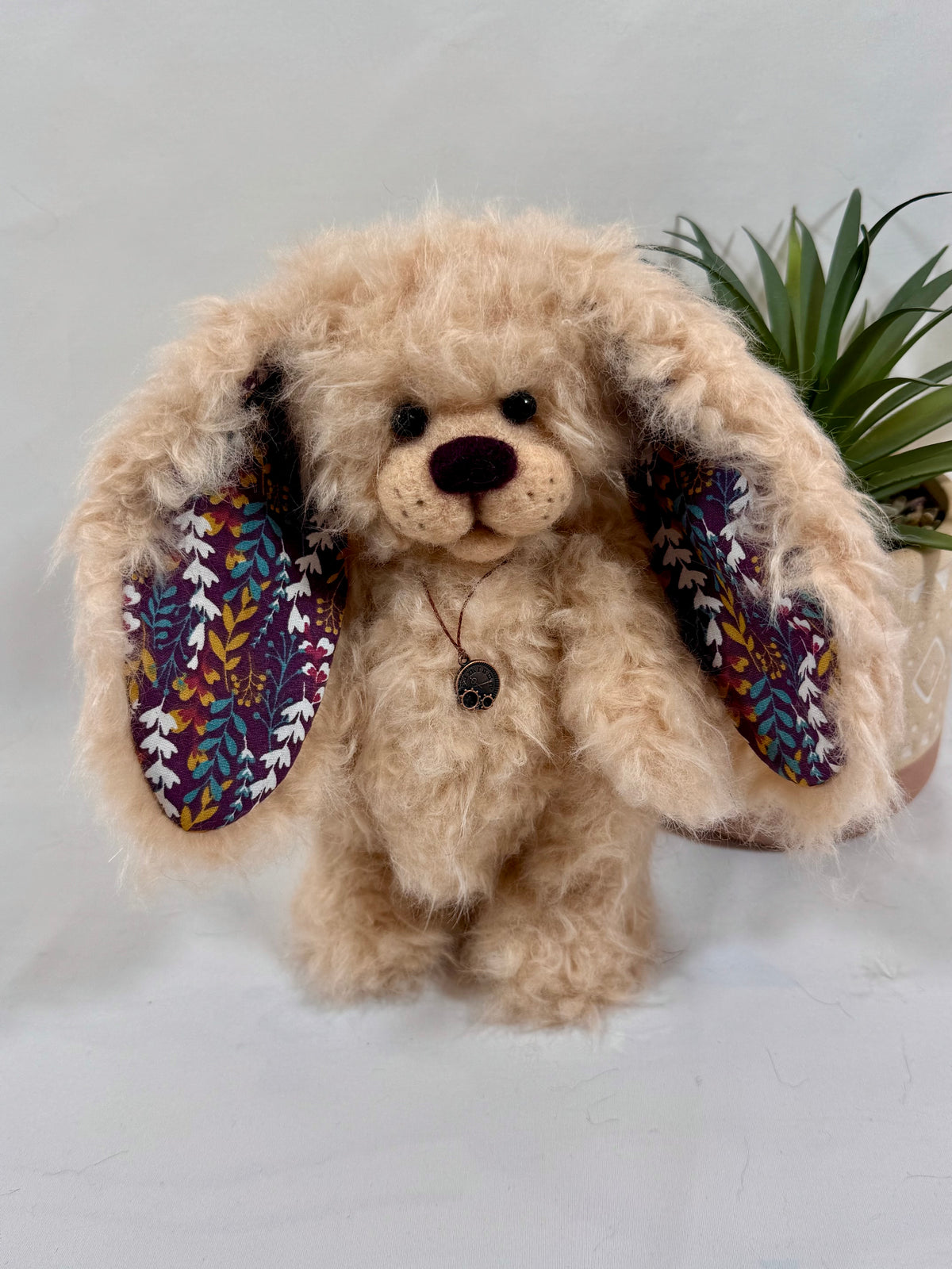 Lapin de collection Pomponette de 20 cm, avec coussinets en tissu fleuri, oreilles doublées de tissu à motifs et pendentif vintage.