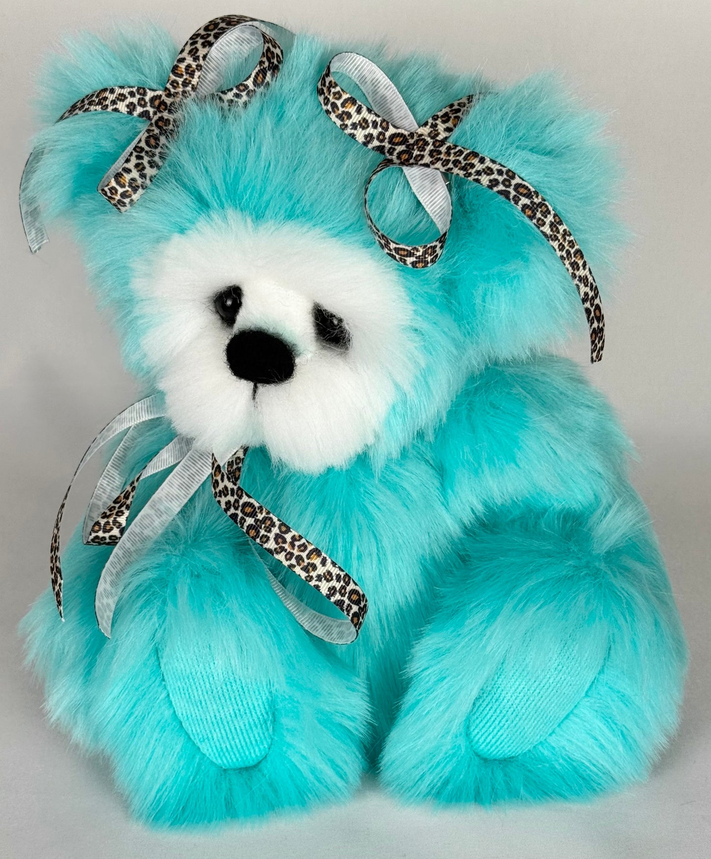 Profil de l’ourse de collection Safari, peluche artisanale en fausse fourrure turquoise, montrant les détails du museau sculpté, du nez feutré à l’aiguille et des articulations vintage.