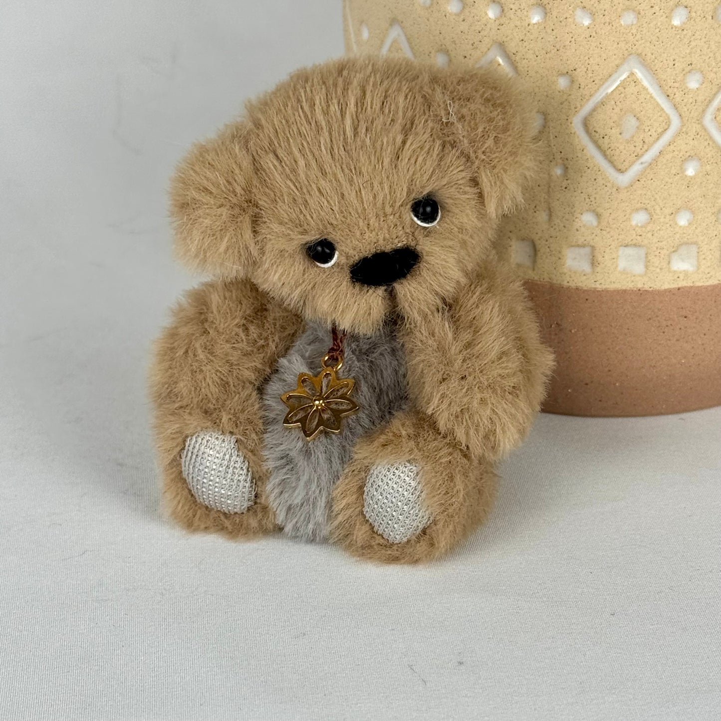 Peluche de collection faite main – ours articulé de 10 cm avec médaillon en argent et finitions soignées.