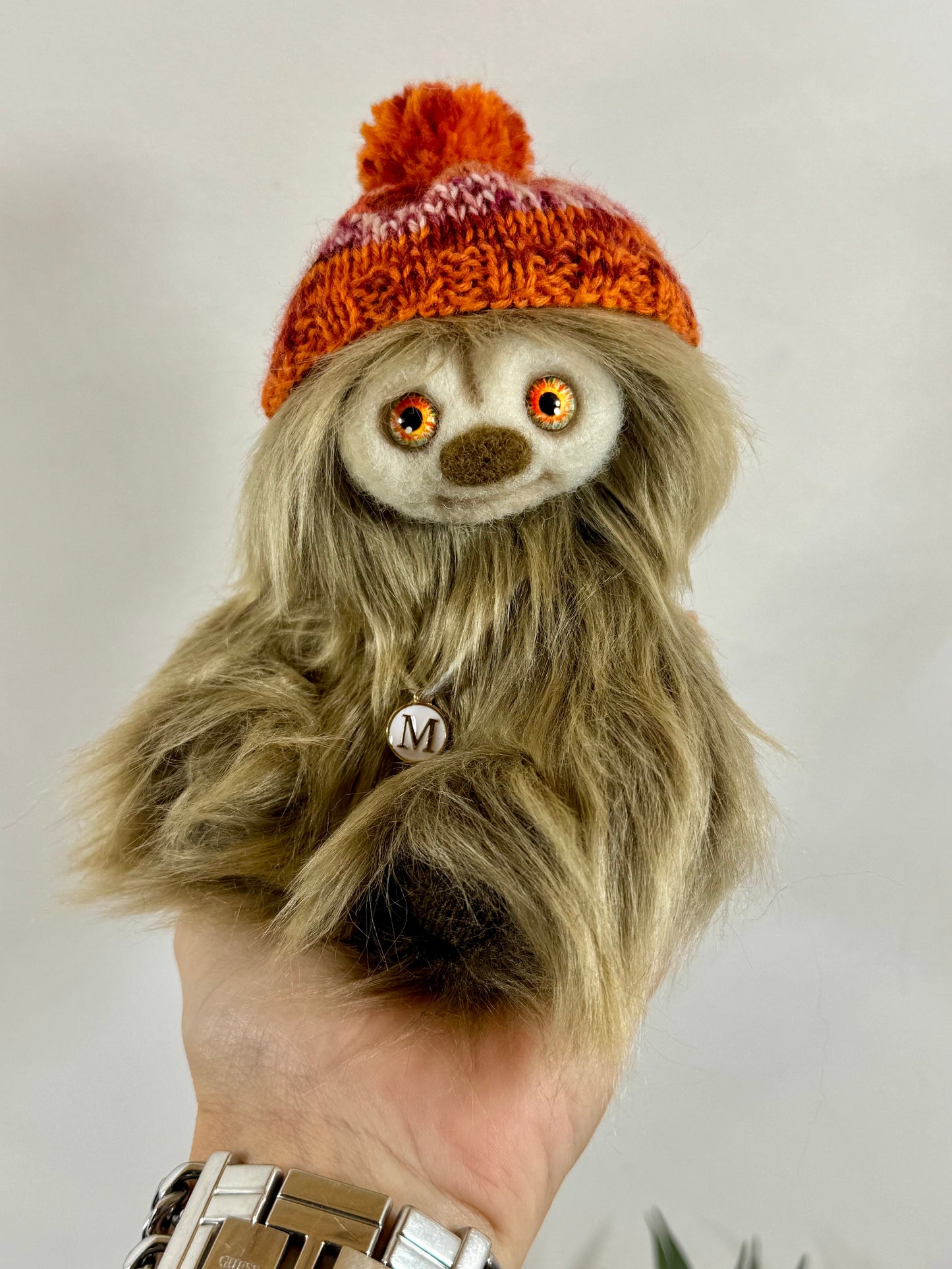 Détail du visage de Moka, peluche artisanale aux yeux en verre orangés et nez feutré à l’aiguille