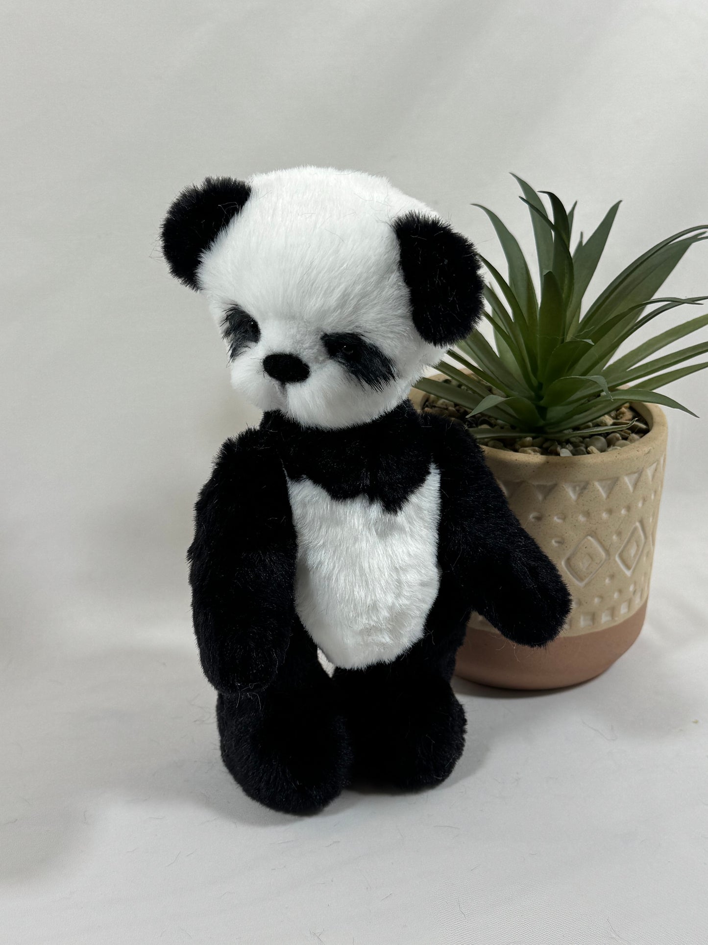Gros plan sur le visage de Pandi, panda de collection aux yeux de verre et nez feutré main