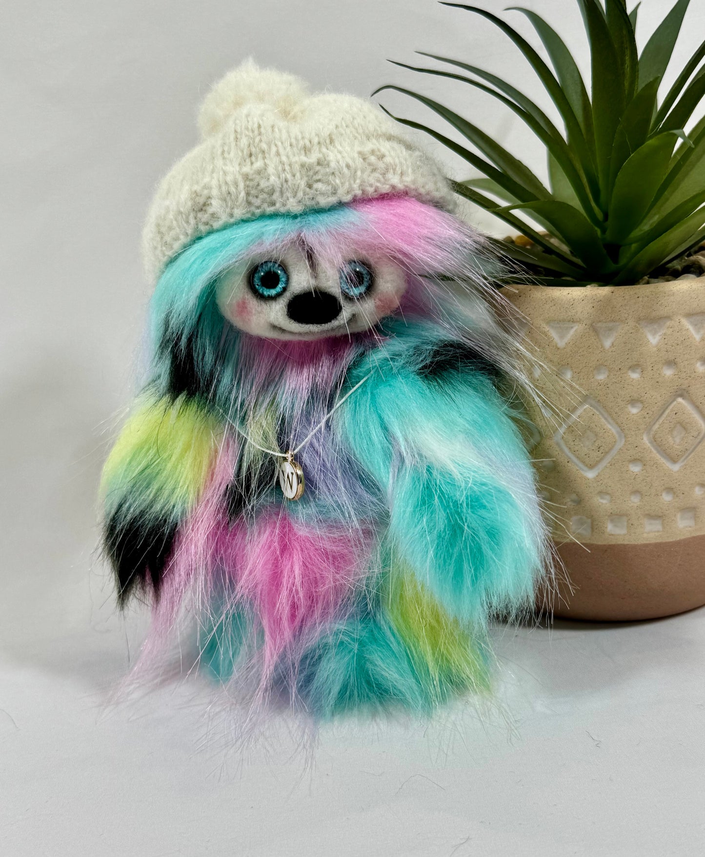 Détail du visage de Wina, peluche artisanale aux yeux en verre bleu et nez noir feutré à l’aiguille