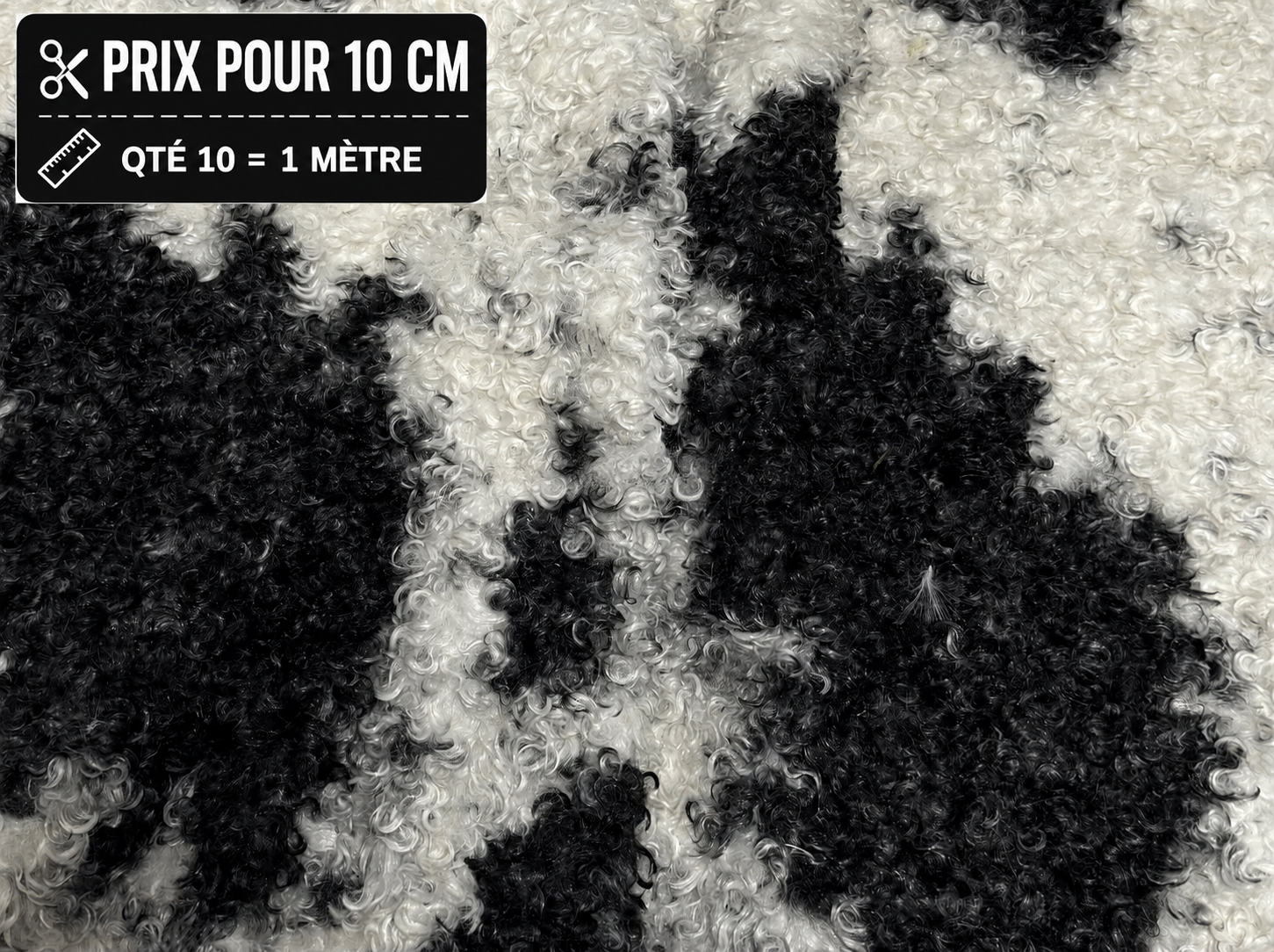 Fausse fourrure frisée noire et blanche à poils 1,5 cm vendue à la coupe