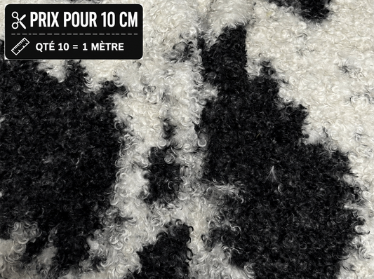 Fausse fourrure frisée noire et blanche à poils 1,5 cm vendue à la coupe