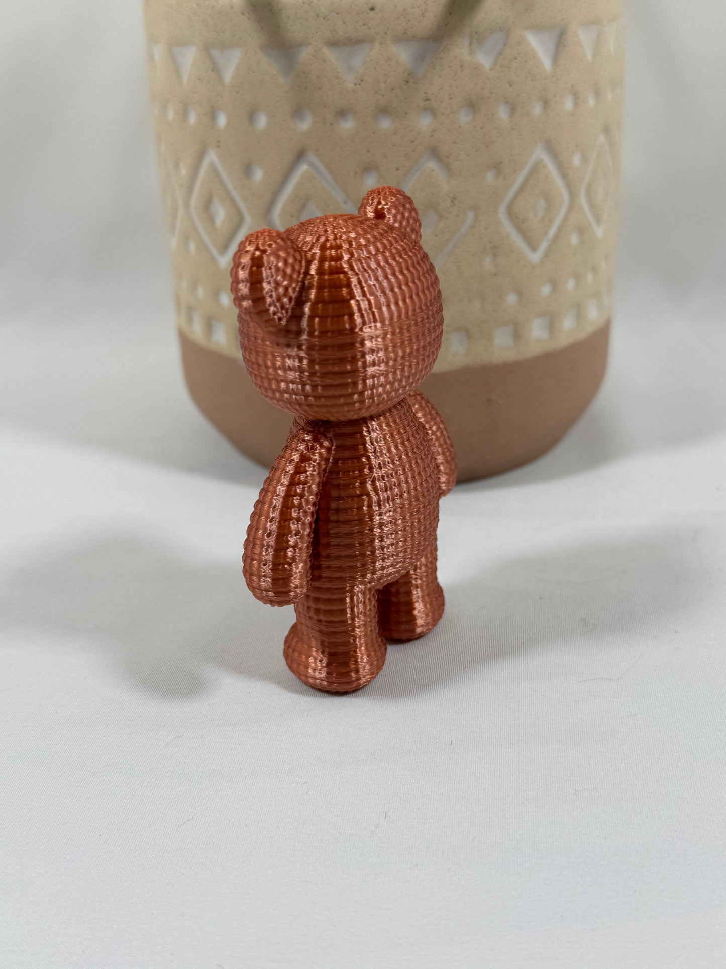 Petit ours cuivre imprimé en 3D avec finition soyeuse et texture imitation crochet.