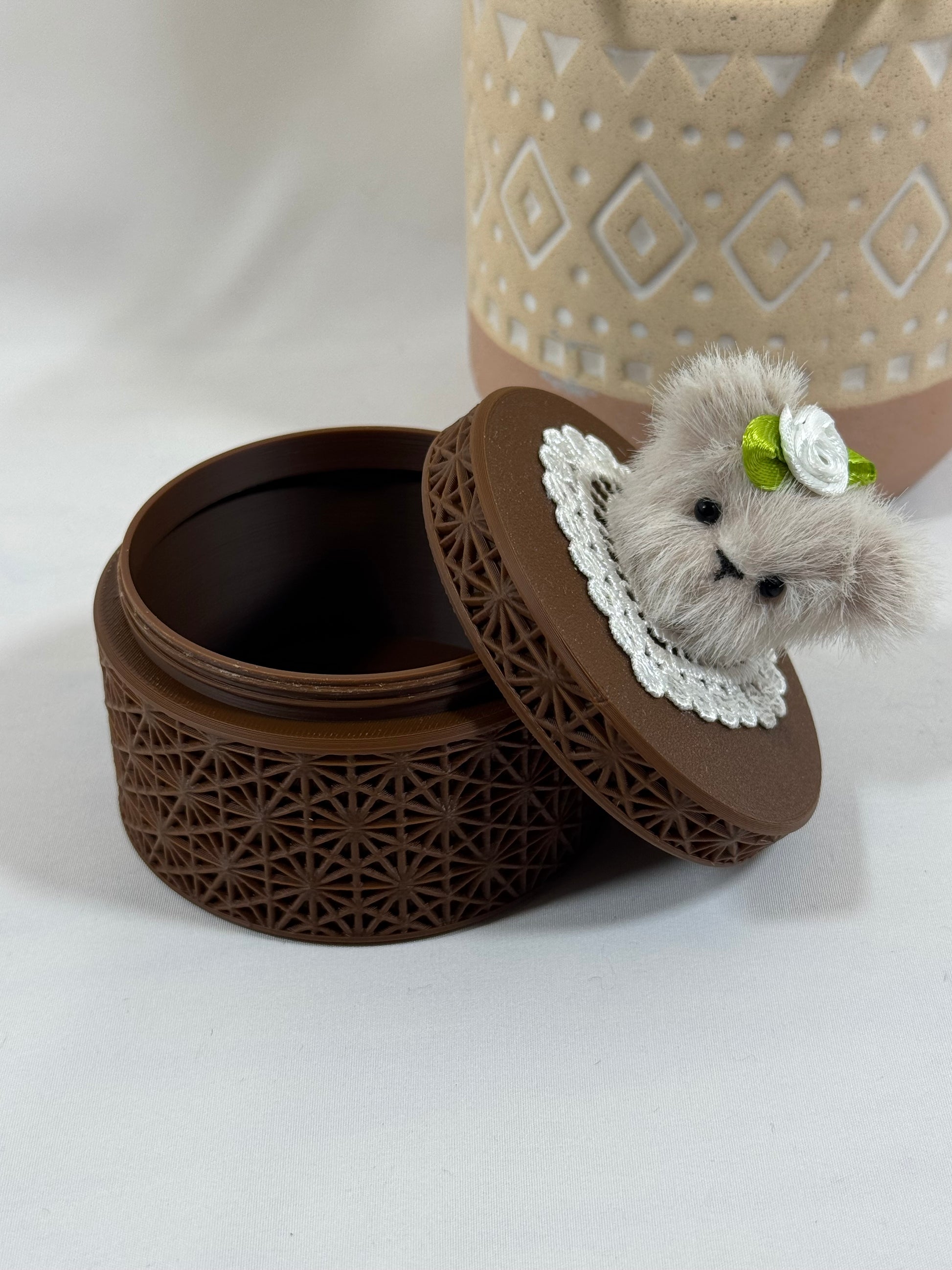 Boîte ronde marron à visser avec motif géométrique et tête d'ours beige cousue à la main.