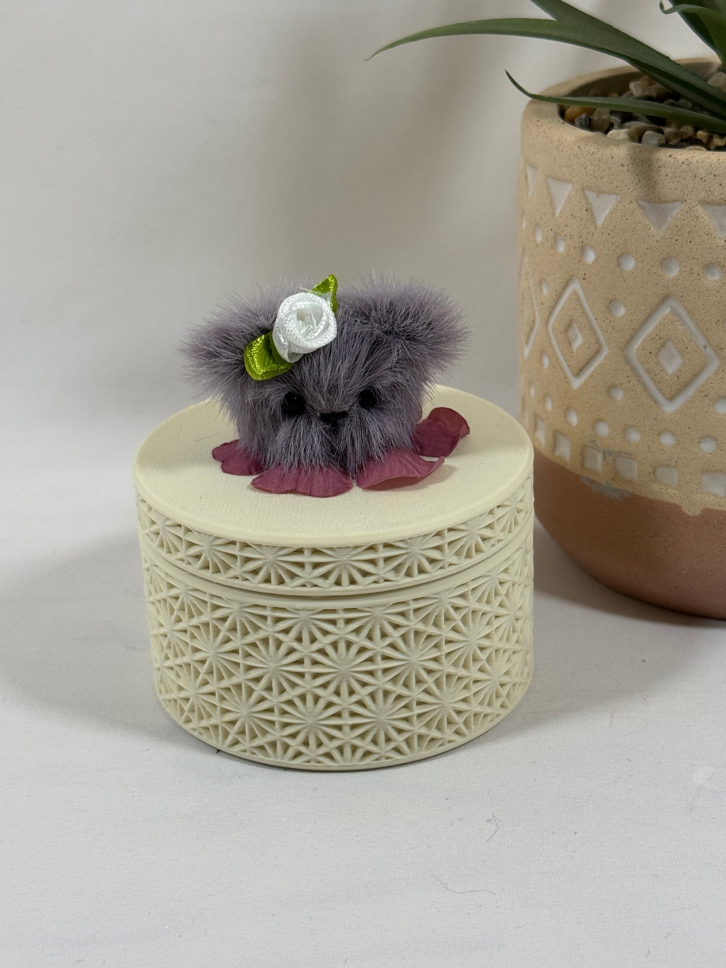 Boîte décorative géométrique crème imprimée en 3D avec couvercle à visser et tête d'ours en fausse fourrure mauve foncé.