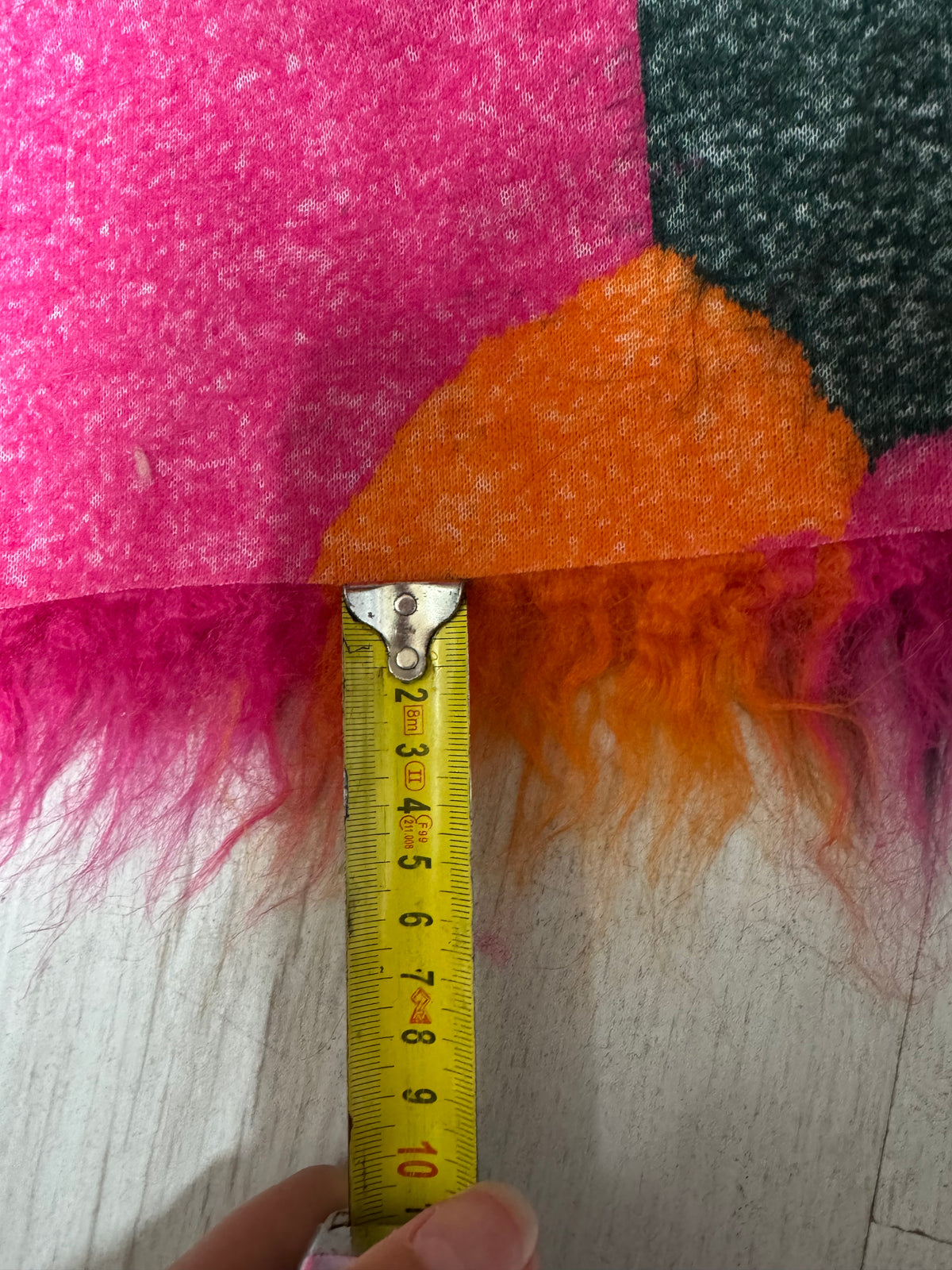 Détail fausse fourrure frisée à poils longs 6 cm coloris fuchsia orange et vert foncé