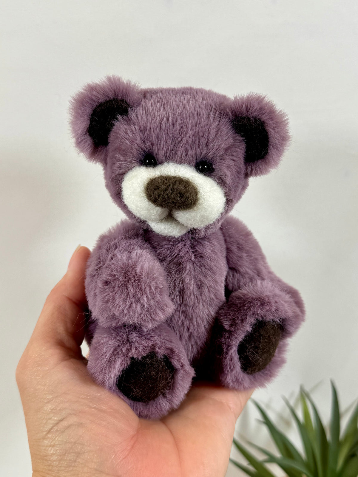 Petit ours artisanal Pimousse de 14 cm, entièrement articulé, avec pelage mauve doux, oreilles aux intérieurs marron et coussinets assortis.