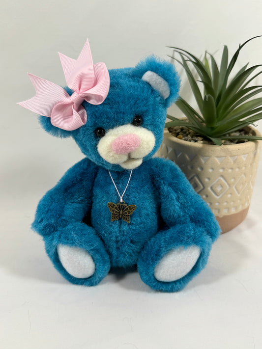 Papillotte, ourse de collection articulée 20 cm en fausse fourrure bleu turquoise avec nœud rose, création artisanale française.