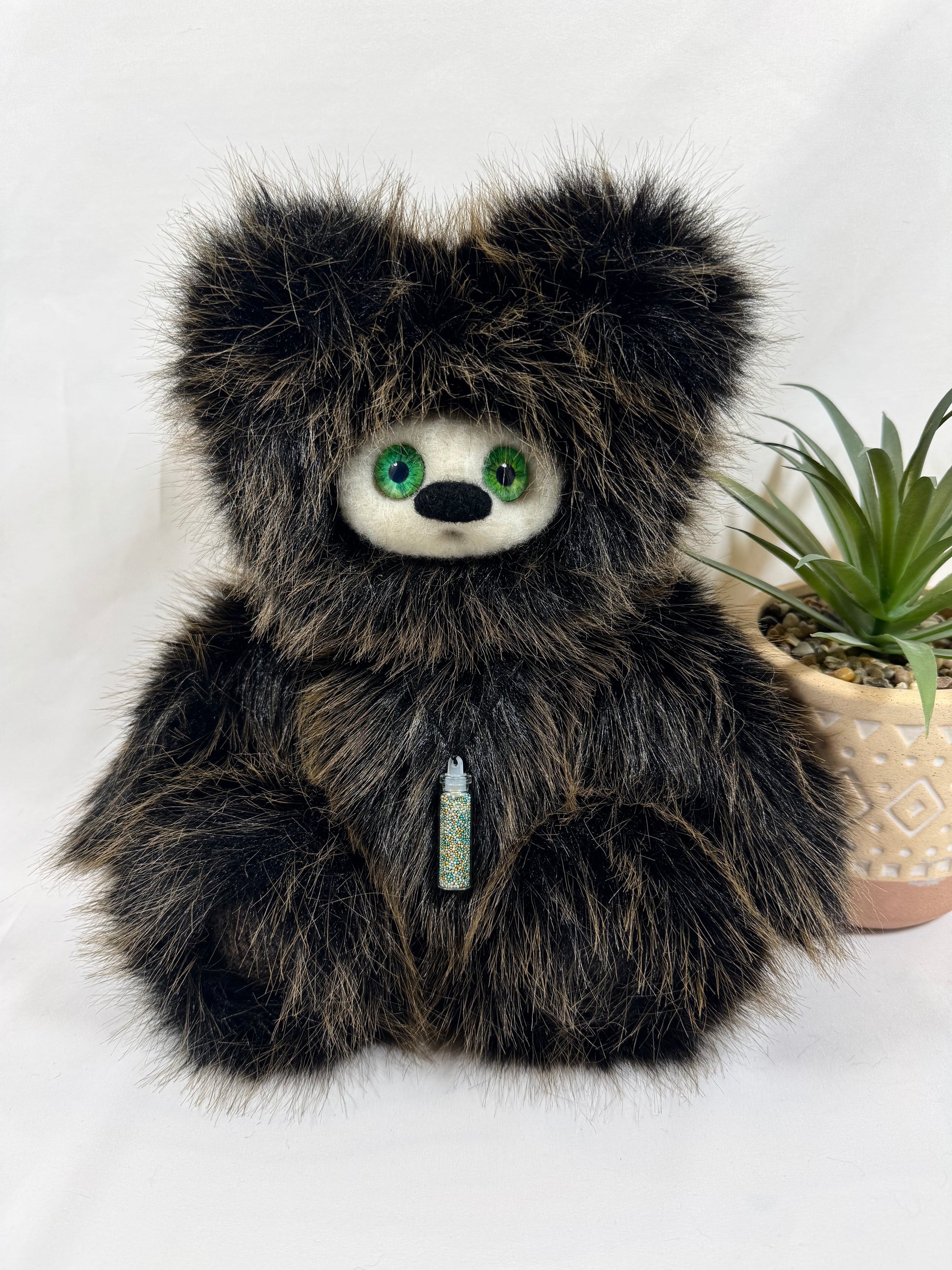 Frimousse Signature Sylvae 30 cm, peluche artisanale faite main en fausse fourrure brun noir, yeux verts