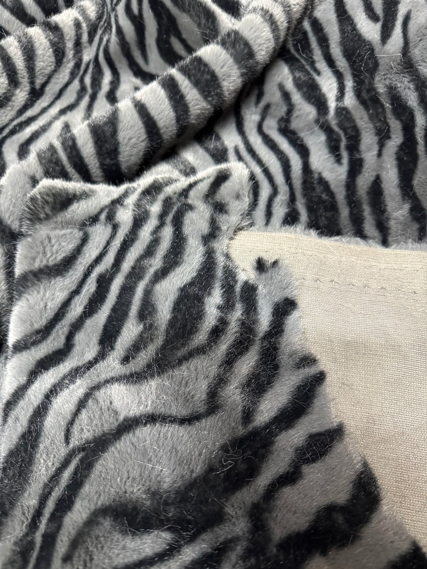 Coupon tissu fausse fourrure zébrée gris noir 30x168 cm – poils 1,5 cm