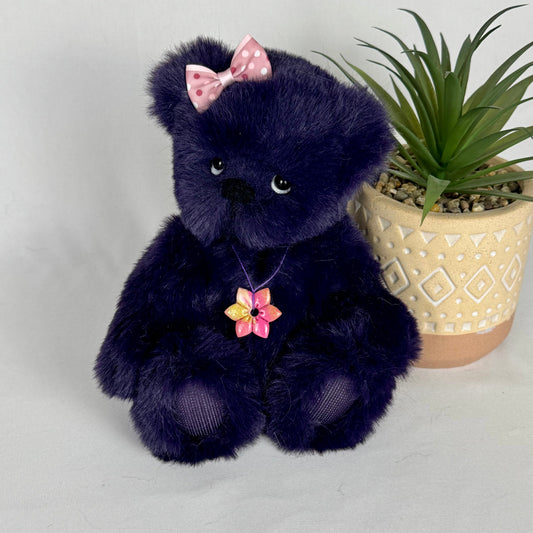 Ours de collection Lavalou en fausse fourrure violette avec fleur au cou, vue de face