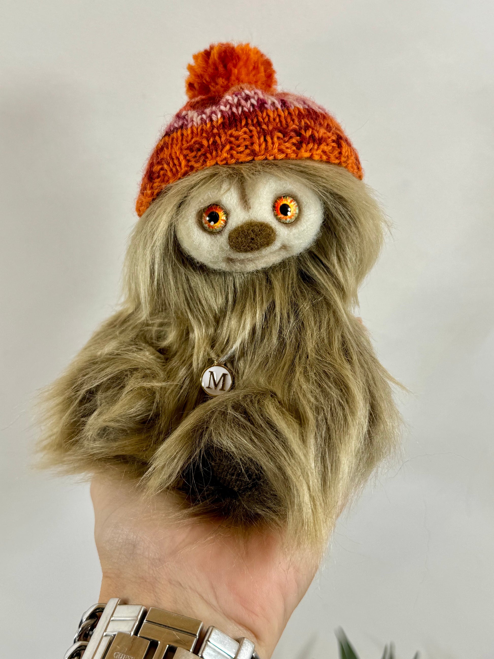 Détail du visage de Moka, peluche artisanale aux yeux en verre orangés et nez feutré à l’aiguille